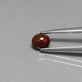 0.32カラットの天然マルチカラーチョコレートオパール（5.5×4.5 mm・オーバルカット）