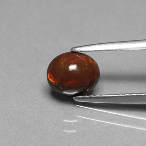 0.75カラットの天然マルチカラーチョコレートオパール（7×5.8 mm・オーバルカット）